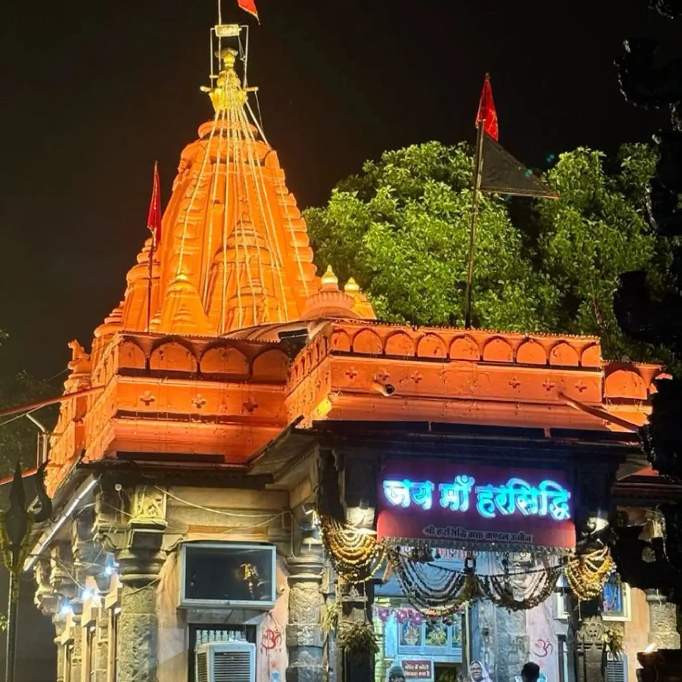 Orange shikhara of the Harsiddhi Mata temple lit at dusk